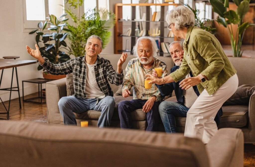 Group of seniors enjoying drinks and conversation in a cozy common room during a social gathering