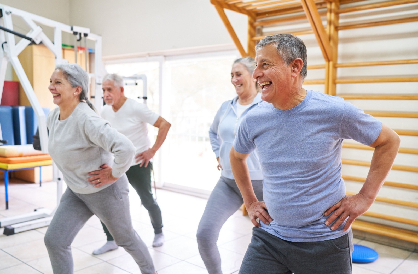 4 senior friends in a workout studio performing hip exercises
