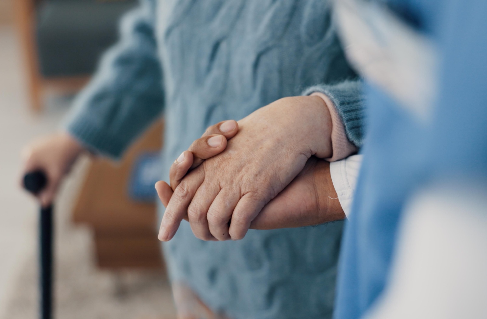 An assisted living caregiver embraces a senior resident in their community apartment.